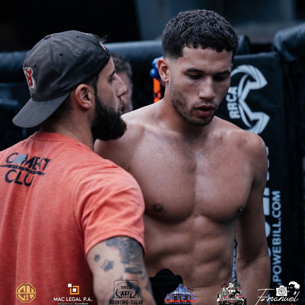 A coach talking a fighter through their corner between rounds